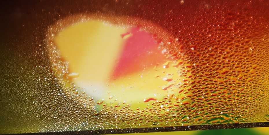 Eine mit Nanopartikeln beschichtete Scheibe wurde im ETH-Labor in der Mitte mit Licht beschienen, weshalb sie dort nicht beschlug. (Bild: ETH Zürich / Christopher Walker)